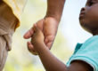 close up shot of a young child holing an adult's hand