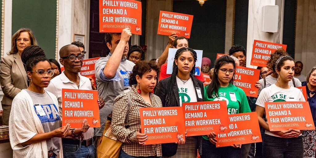 Philadelphia Fair Workweek_ Source Philadelphia Inquirer Organizers hold "Philly workers demand a fair workweek" signs in City Council.