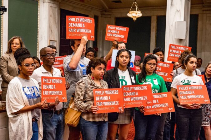 Philadelphia Fair Workweek_ Source Philadelphia Inquirer Organizers hold "Philly workers demand a fair workweek" signs in City Council.